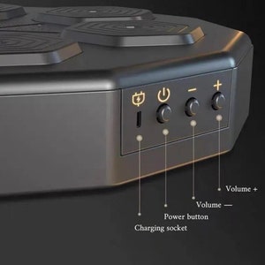 May include: A black wireless charging station with a hexagonal design. It has a charging socket, power button, and volume controls. The top has four circular charging pads. Text labels the charging socket, power button, and volume controls.