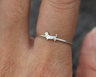 May include: A silver ring with a small dachshund silhouette design.
