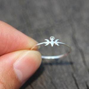 May include: A silver ring with a triple moon and a human figure design.