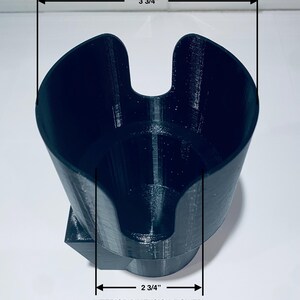 May include: Black, 3D-printed cup holder with a unique design. The upper interior dimension is 3 3/4 inches, and the lower interior dimension is 2 3/4 inches. The text on the image reads "INTERIOR DIMENSION (UPPER)" and "INTERIOR DIMENSION (LOWER)".