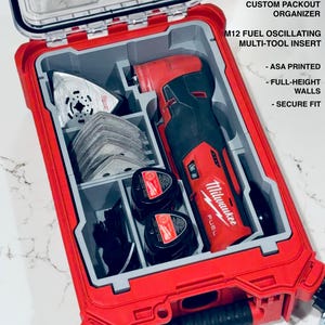 May include: A red and gray custom Packout organizer with a clear lid, containing a M12 Fuel oscillating multi-tool, blades, and accessories. The text on the organizer reads "CUSTOM PACKOUT ORGANIZER" and "M12 FUEL OSCILLATING MULTI-TOOL INSERT".