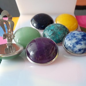 Peut inclure: Un ensemble de sept boucles d'oreilles en pierres précieuses avec des montures argentées. Les pierres précieuses sont de différentes couleurs, notamment le vert, le bleu, le violet et le jaune.