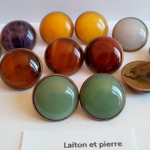 Peut inclure: Un ensemble de 10 paires de boucles d'oreilles avec des pierres de différentes couleurs. Les boucles d'oreilles sont en laiton et ont une fermeture à clip. Les pierres sont l'améthyste, l'ambre, la citrine, l'aventurine verte et le jaspe rouge.