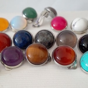 Peut inclure: Une collection de boutons de manchette en pierres précieuses colorées, avec des montures en métal argenté. Les boutons de manchette présentent une variété de couleurs, dont le jaune, le rouge, le bleu, le vert, le violet, le marron, le noir, le blanc, le rose et le turquoise. Les pierres sont rondes et polies.