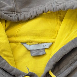 May include: A white ceramic mug with a black handle and the text "But First, Coffee" in a bold, black font. The mug sits on a white surface, showcasing its clean design.