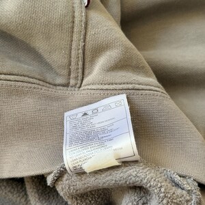 May include: A white ceramic mug with a black handle and the text "But First, Coffee" in a black, bold font. The mug is sitting on a white surface. The mug appears to be 4 inches tall.