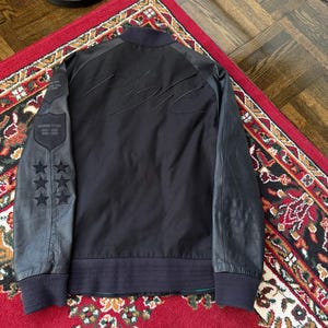 Może przedstawiać: Rustykalny drewniany znak z napisem "Welcome to our home" w białych literach. Znak ma postarzaną powierzchnię i prosty, zachęcający design, idealny do dekoracji wejścia.