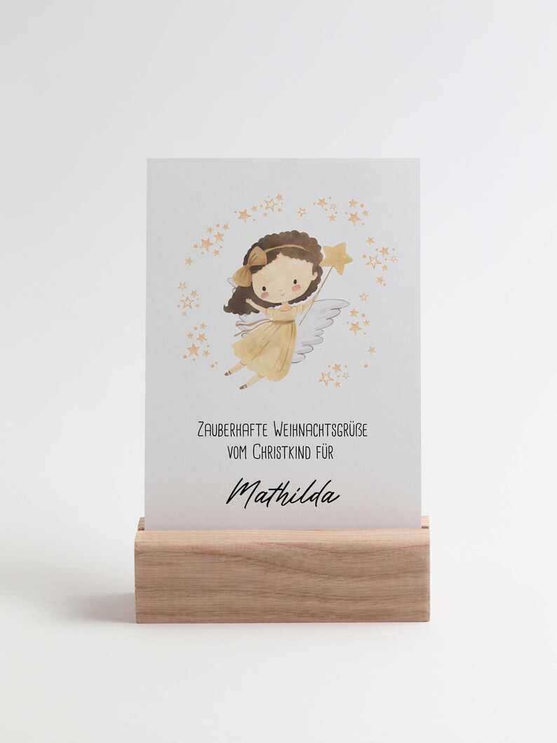 Niedliche Christkind-Weihnachtskarte mit Personalisierung. Auf der Karte steht „Zauberhafte Weihnachtsgrüße vom Christkind für [Name]“. Das Motiv zeigt ein Engelchen mit goldenen Haaren und Sternenzauber – perfekt für Weihnachtsgrüße an Kinder.