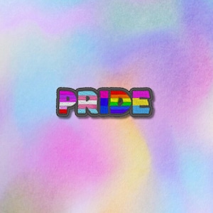 Pode incluir: Uma bandeira do orgulho arco-íris com a palavra "PRIDE" escrita em letras coloridas. As letras são contornadas em preto e têm uma textura difusa.