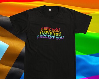 Puede incluir: Una camiseta negra de manga corta con el texto I SEE YOU I LOVE YOU I ACCEPT YOU impreso en una fuente con degradado de arcoíris multicolor en el pecho. La prenda tiene cuello redondo y un corte estándar con mangas cortas.