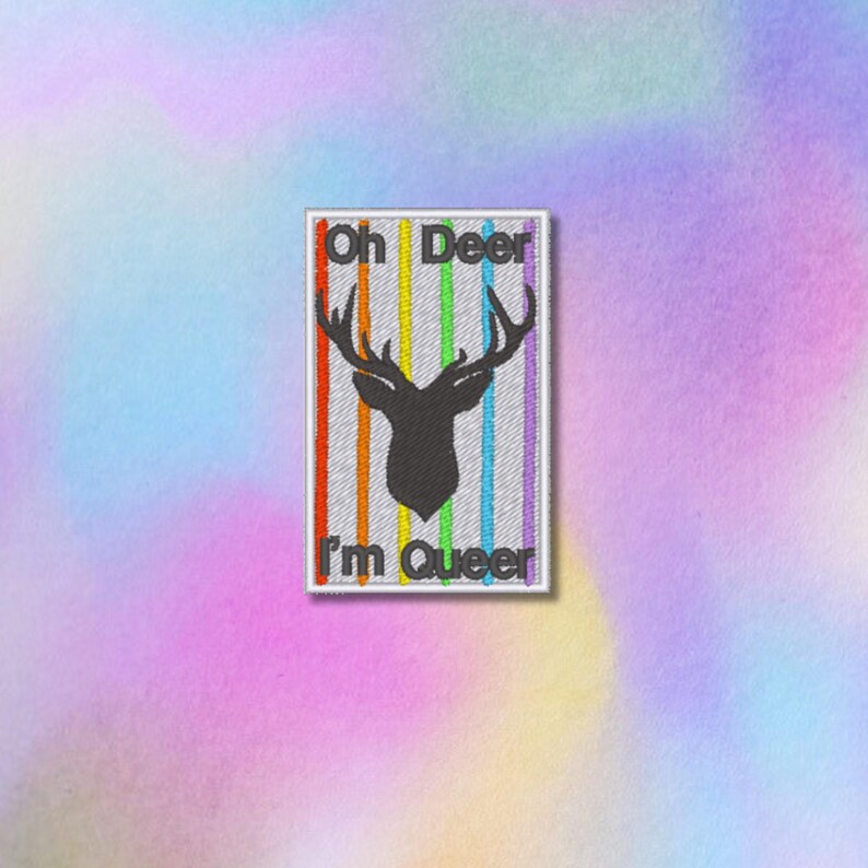 May include: A white patch with a rainbow stripe design and a black silhouette of a deer head with antlers. The text "Oh Deer I'm Queer" is printed on the patch.
