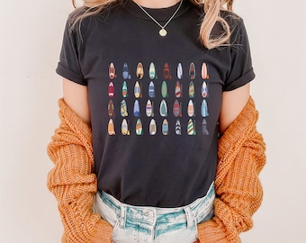 May include: A black t-shirt with a colorful pattern of paddleboards. The paddleboards are arranged in rows and are all different colors and designs.