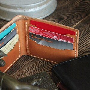 May include: A brown leather wallet with multiple card slots, showing a few cards with the text "Абсолют Банк" in Cyrillic script.