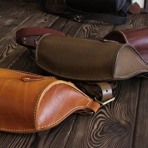 May include: Three leather bags in different shades of brown. The bags are all made of a soft, supple leather and have a simple, classic design. The bags are all closed with a buckle.
