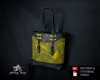 May include: A black and green leather tote bag with gold accents and a top handle. The bag has a flap with a diamond-shaped detail and a contrasting black bottom.