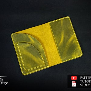 Puede incluir: Un portapasaporte de cuero amarillo con un bolsillo en el interior. El portapasaporte está abierto y el interior es visible. El texto "Heavy Boy" es visible en la esquina inferior izquierda de la imagen.