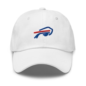 Puede incluir: Gorra de béisbol blanca con visera curva. La gorra presenta un logotipo bordado en azul y rojo. El logotipo es una representación estilizada de un búfalo. La gorra está hecha de un material suave y duradero.