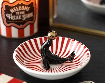 Circus style quirky trinket dish featuring a black circus seal balancing a golden ball gothic alternative twisted circus range