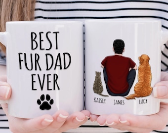 May include: White ceramic mug with the text "Best Fur Dad Ever" and a paw print on one side. The other side features a drawing of a man sitting with a cat and a dog, with the names "Kaisley", "James", and "Lucy" written below.