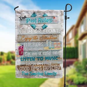 May include: A wooden sign with the text "The Pool Rules" in blue and white lettering. The sign also includes the text "Swim or Float", "Enjoy the Sunshine", "Flip Flops Recommended", "Sip on a cold one", "Listen to Music", "Laugh and Play", "Good Times Expected", and "The Smiths Family".
