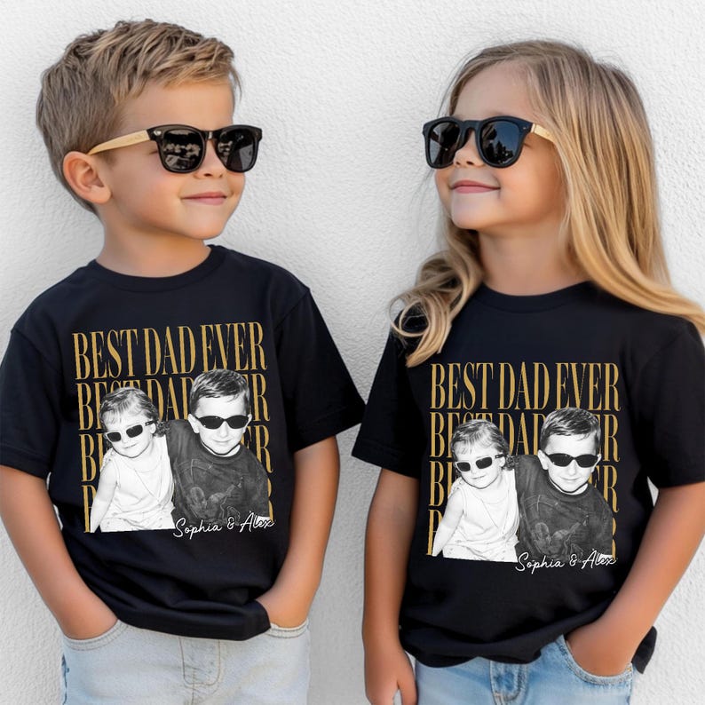 Pode incluir: Duas crian&ccedil;as vestindo camisetas pretas com o texto dourado "BEST DAD EVER". As camisetas apresentam uma foto em preto e branco de duas crian&ccedil;as usando &oacute;culos de sol. Os nomes "Sophia & Alex" s&atilde;o impressos abaixo.
