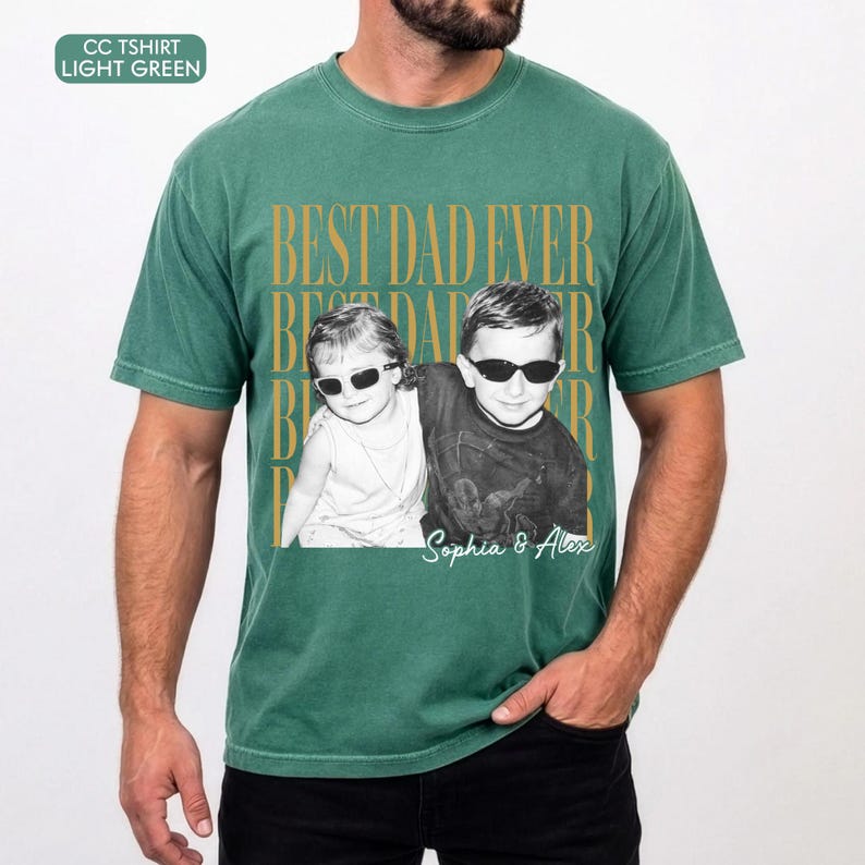 Pode incluir: T-shirt verde claro com a frase dourada "BEST DAD EVER". A camisa apresenta uma foto a preto e branco de duas crian&ccedil;as com &oacute;culos de sol, com os nomes "Sophia & Alex" por baixo.