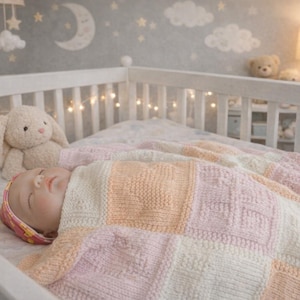May include: A baby sleeps in a white cot, wrapped in a soft, pastel-coloured knitted blanket. A plush bunny sits beside the baby. The nursery has a grey wall with moon and star decorations, and a warm lamp.