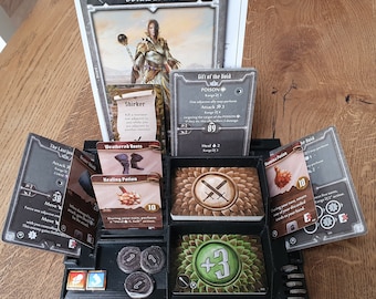 Pode incluir: Um jogo de tabuleiro com uma variedade de cartas e fichas. As cartas apresentam ilustrações de personagens e monstros, e as fichas são usadas para rastrear a saúde e outras estatísticas do jogo. O jogo se passa em um mundo de fantasia e apresenta uma variedade de criaturas e feitiços diferentes.