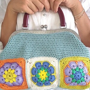 The bag is finished with a sturdy metal kiss lock clasp and elegant dark handles, making it perfect for both casual outings and special occasions.