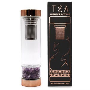 May include: A clear glass tea infuser bottle with a copper-coloured lid and base. The bottle contains a stainless steel infuser and amethyst gemstone chips. The black box next to it reads "TEA INFUSER BOTTLE" in copper lettering.