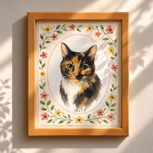 Könnte beinhalten: Ein gerahmtes Aquarellbild einer Glückskatze mit schwarzem, orangefarbenem und weißem Fell. Die Katze ist in einem ovalen Rahmen zentriert, der von einem zarten Kranz aus kleinen rosa und gelben Blumen mit grünen Blättern umgeben ist. Der Name Molly steht darunter.