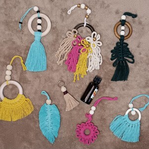 Puede incluir: Surtido de amuletos de coche de macramé hechos a mano con anillos de madera, borlas de colores y cuentas. Los amuletos son de varios colores, incluyendo azul, verde, amarillo, rosa y blanco.