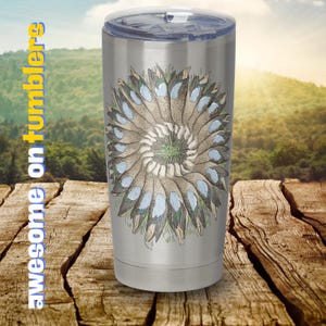 May include: A stainless steel travel mug with a floral design in blue and brown. The text "awesome on tumblers" is printed vertically. The mug has a clear lid.