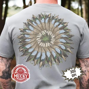 May include: Grey t-shirt with a circular duck design in shades of brown, blue, and green, centered on the back. The shirt includes a "Mucky Original" logo and a "300 DPI" graphic.