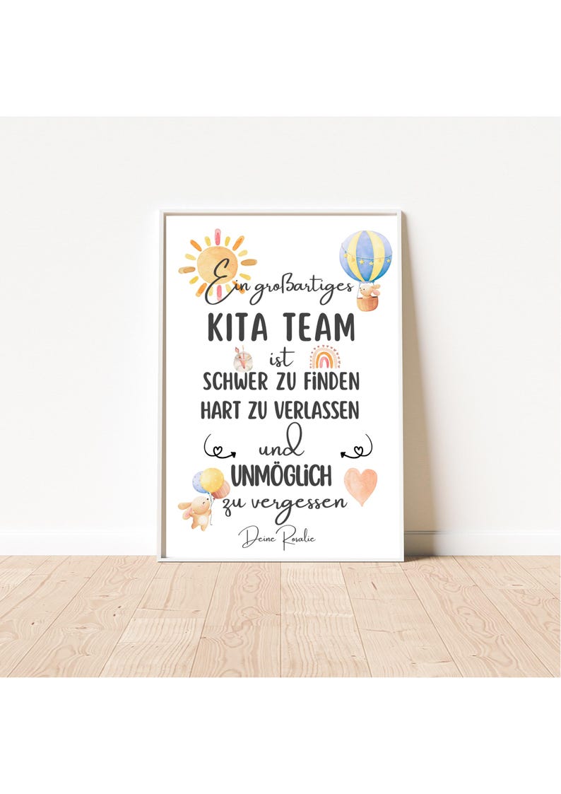 May include: A framed print with the text "Ein gro&szlig;artiges KITA TEAM ist SCHWER ZU FINDEN HART ZU VERLASSEN und UNM&Ouml;GLICH zu vergessen Deine Rovalic." The print features watercolor illustrations of a sun, hot air balloon, rainbow, and hearts.