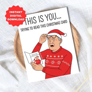 Könnte beinhalten: Eine humorvolle Weihnachtskarte mit dem Text "THIS IS YOU... TRYING TO READ THIS CHRISTMAS CARD." Die Karte zeigt eine Cartoon-Illustration eines Mannes mit Weihnachtsmütze und rotem Pullover, der versucht, eine kleinere Karte zu lesen.
