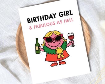 May include: A white greeting card with the text "BIRTHDAY GIRL & FABULOUS AS HELL". The card features a cartoon character wearing sunglasses, holding a wine glass and a bottle of wine. The character is wearing a red dress and a green collar.