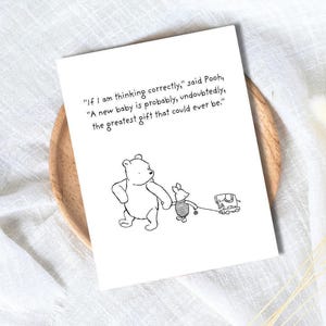Peut inclure: Une carte de vœux blanche avec une illustration de Winnie l'ourson. Le dessin en noir et blanc montre Winnie et Porcinet avec un petit chariot jouet. La carte contient une citation : "Si je pense correctement", dit Winnie, "Un nouveau bébé est probablement, sans aucun doute, le plus beau cadeau qui puisse exister."