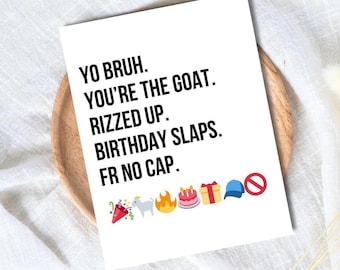 Puede incluir: Una tarjeta de felicitación blanca con texto negro que dice "YO BRUH. YOU'RE THE GOAT. RIZZED UP. BIRTHDAY SLAPS. FR NO CAP." con varios emojis. La tarjeta está sobre un plato de madera.
