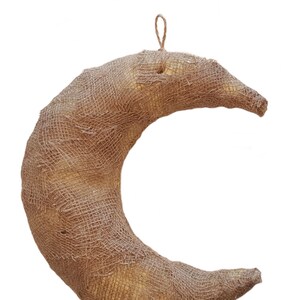 Könnte beinhalten: Ein brauner, sichelförmiger Kranz aus Jute.