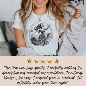 May include: A white t-shirt with a black and white illustration of a mermaid in a circle. The text "Fizz Candy Designs" is included in the customer review.