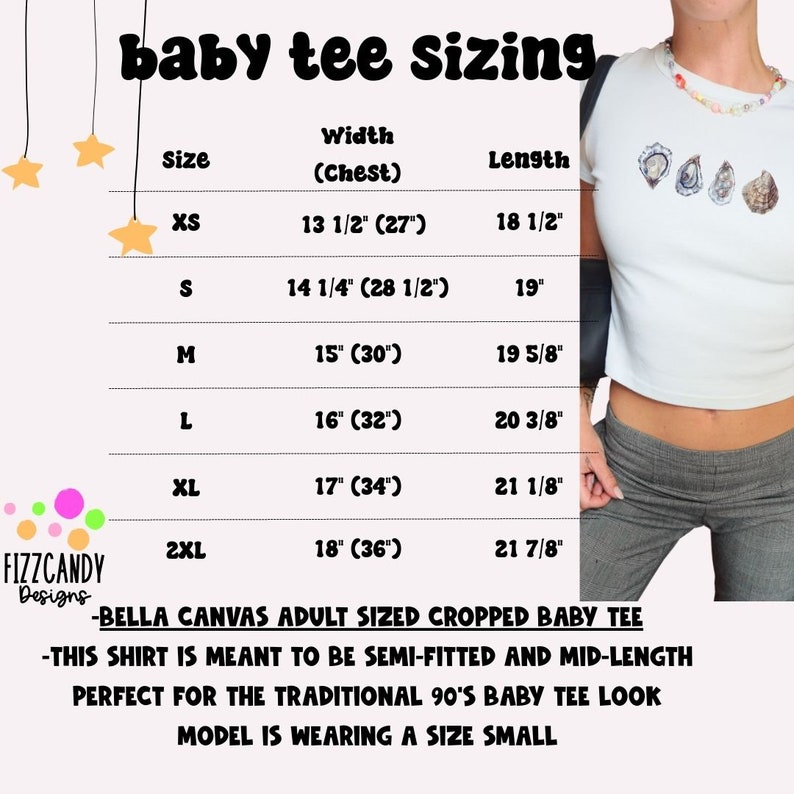 Może przedstawiać: Tabela rozmiar&oacute;w dla obciętej koszulki typu baby tee, pokazująca szerokość i długość w calach dla rozmiar&oacute;w od XS do 2XL. Tabela znajduje się na r&oacute;żowym tle z ż&oacute;łtymi gwiazdami i tekstem "baby tee sizing" u g&oacute;ry. Modelka nosi rozmiar S.