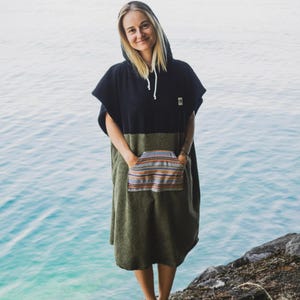 Może przedstawiać: Zestaw trzech ceramicznych kubków z nakrapianym, matowym wykończeniem. Kubki są w odcieniach kremu, jasnoszarym i ciemnoszarym. Każdy kubek ma prosty, minimalistyczny design i zaokrąglony uchwyt.