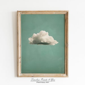 Puede incluir: Una impresión enmarcada de una sola nube blanca sobre un fondo azul verdoso. La impresión está en un marco de madera clara y tiene el texto "Timeless Prints 4 You" y "Printable Art" en la parte inferior.