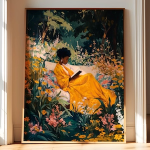 May include: A framed art print depicts a person in a yellow dress reading a book while reclining on a bench surrounded by flowers. The artwork features a lush garden setting with vibrant colors, including yellows, greens, and pinks. The print is displayed in a room with natural light.