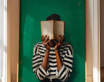 Könnte beinhalten: Ein gerahmtes Kunstwerk, das eine Person zeigt, die ein offenes Buch vor ihrem Gesicht hält. Die Person trägt ein schwarz-weiß gestreiftes Oberteil. Der Hintergrund ist ein leuchtendes Grün. Das Kunstwerk befindet sich in einem goldenen Rahmen und lehnt an einer Wand.