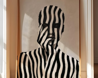 May include: A framed artwork depicting a person's portrait, with a black and white striped pattern across the face and upper body. The artwork is displayed in a room with wooden flooring and a doorway.