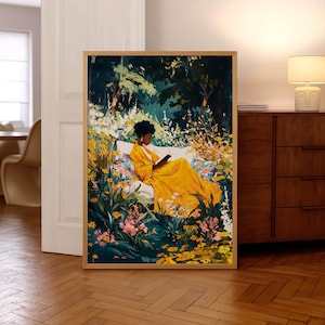 May include: A framed art print depicts a person in a yellow dress reading a book on a white bench surrounded by flowers. The artwork is set in a garden with lush greenery and yellow and pink flowers. The frame is made of light-colored wood.
