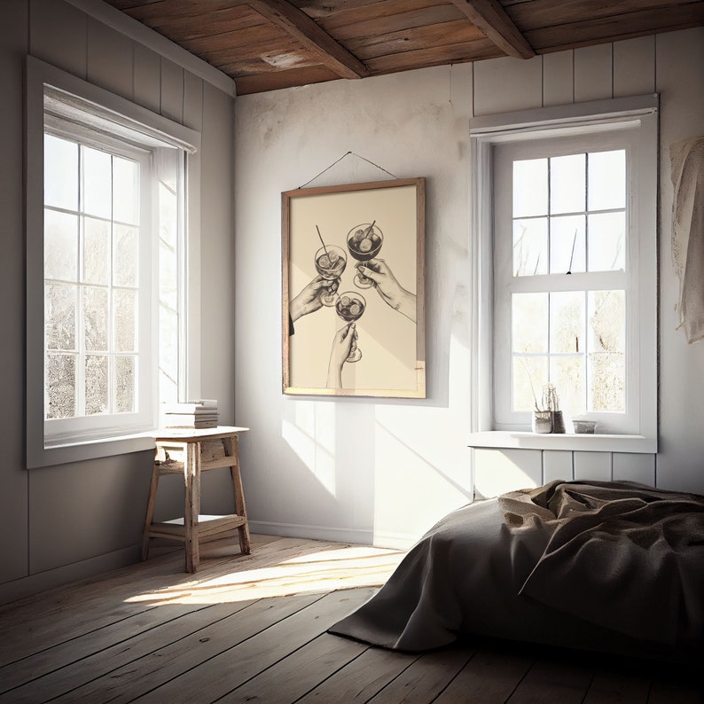 Puede incluir: Una ilustraci&oacute;n en blanco y negro de tres manos sosteniendo copas de martini, con aceitunas en cada copa. La ilustraci&oacute;n est&aacute; enmarcada y colgada en una pared blanca en una habitaci&oacute;n con suelo de madera, una cama y dos ventanas.