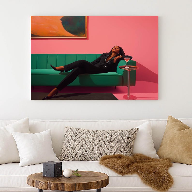 May include: A woman in a black suit reclines on a green sofa against a pink wall. A small side table holds a cocktail. An abstract painting hangs above the sofa. The scene is a stylish, modern interior.